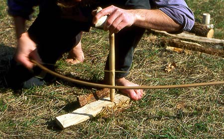 Building fires is a crucial survival skill. Here is a guy making a bow drill fire by friction