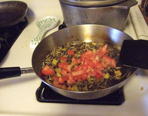 Adding tomatoes to dinner.